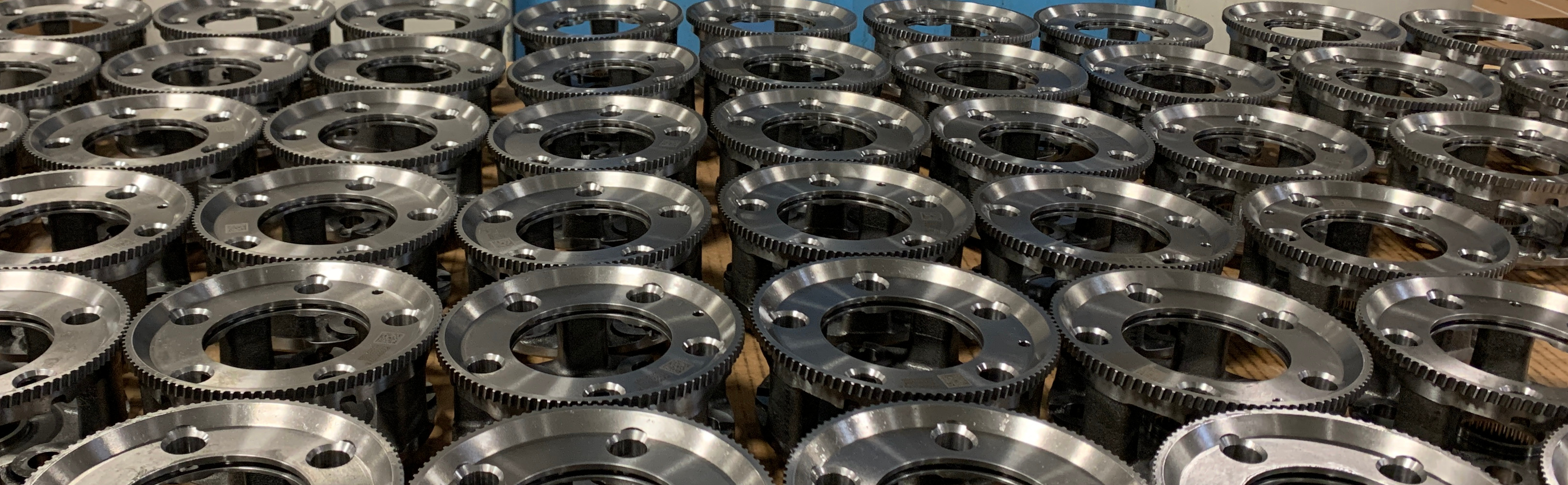 A grid of machined steel parts with gear teeth and mounting holes.